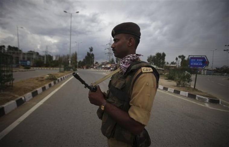 An Indian paramilitary soldier guards a deserted national highway during a curfew on the outskirts of Srinagar, India, Sunday. Police in Indian-administered Kashmir formally accused a key separatist leader of treason Sunday for allegedly inciting violence after participants in a massive anti-India rally torched government offices.